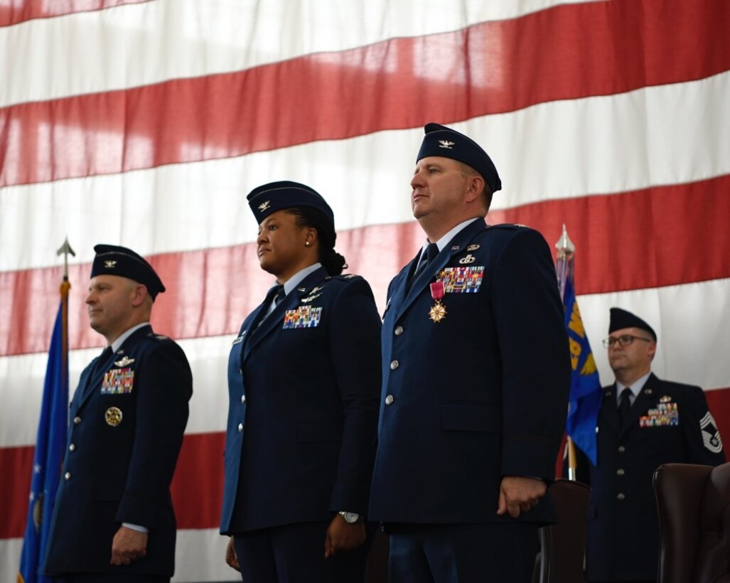 Col. Joseph Sheffield, the 28th Bomb Wing commander, left, Col. Patrice Holmes, the 28th Mission Support Group incoming commander, middle, and Col. Brady Vaira, the 28th Mission Support Group outgoing commander, right, stand for the playing of the Air Force song during a change of command ceremony at Ellsworth Air Force Base, S.D. June 24, 2022.