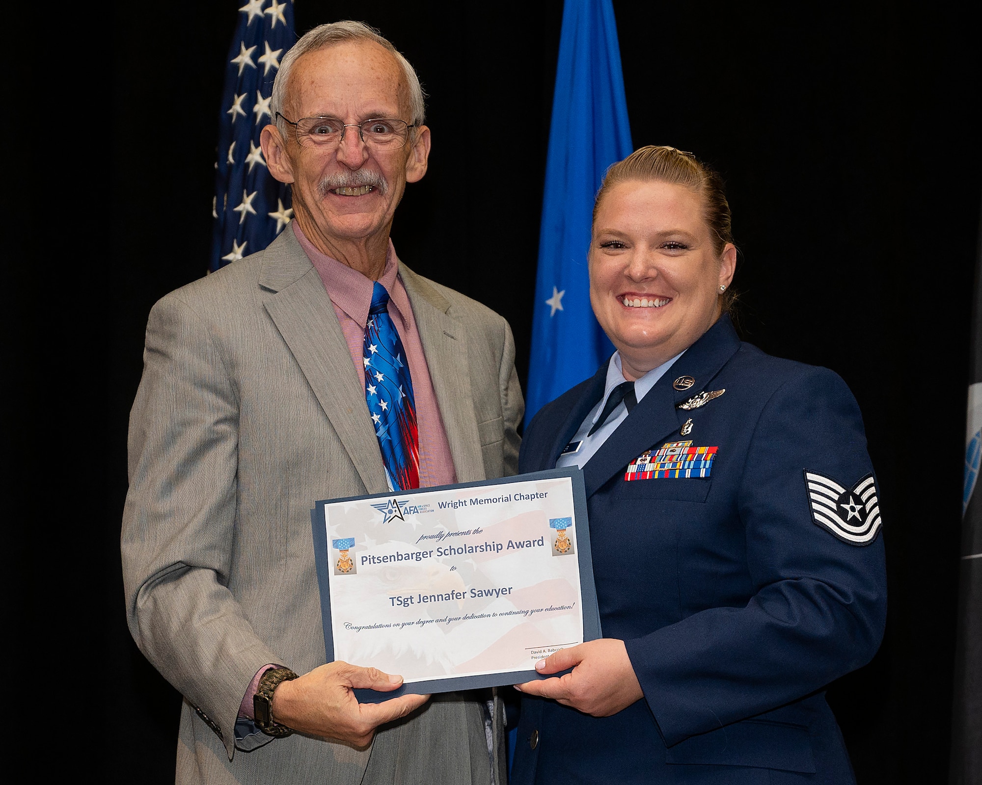 Tech Sgt. Jennafer Sawyer receives the Pitsenbarger Scholarship June 15, 2022, from Air and Space Forces Association Wright Memorial Chapter during the Community College of the Air Force Spring 2022 graduation ceremony at the National Museum of the Air Force, Wright-Patterson Air Force Base, Ohio. The scholarship is a cash award to be used in the continuation of education beyond the associate degree level. (U.S. Air Force photo by R. J. Oriez)