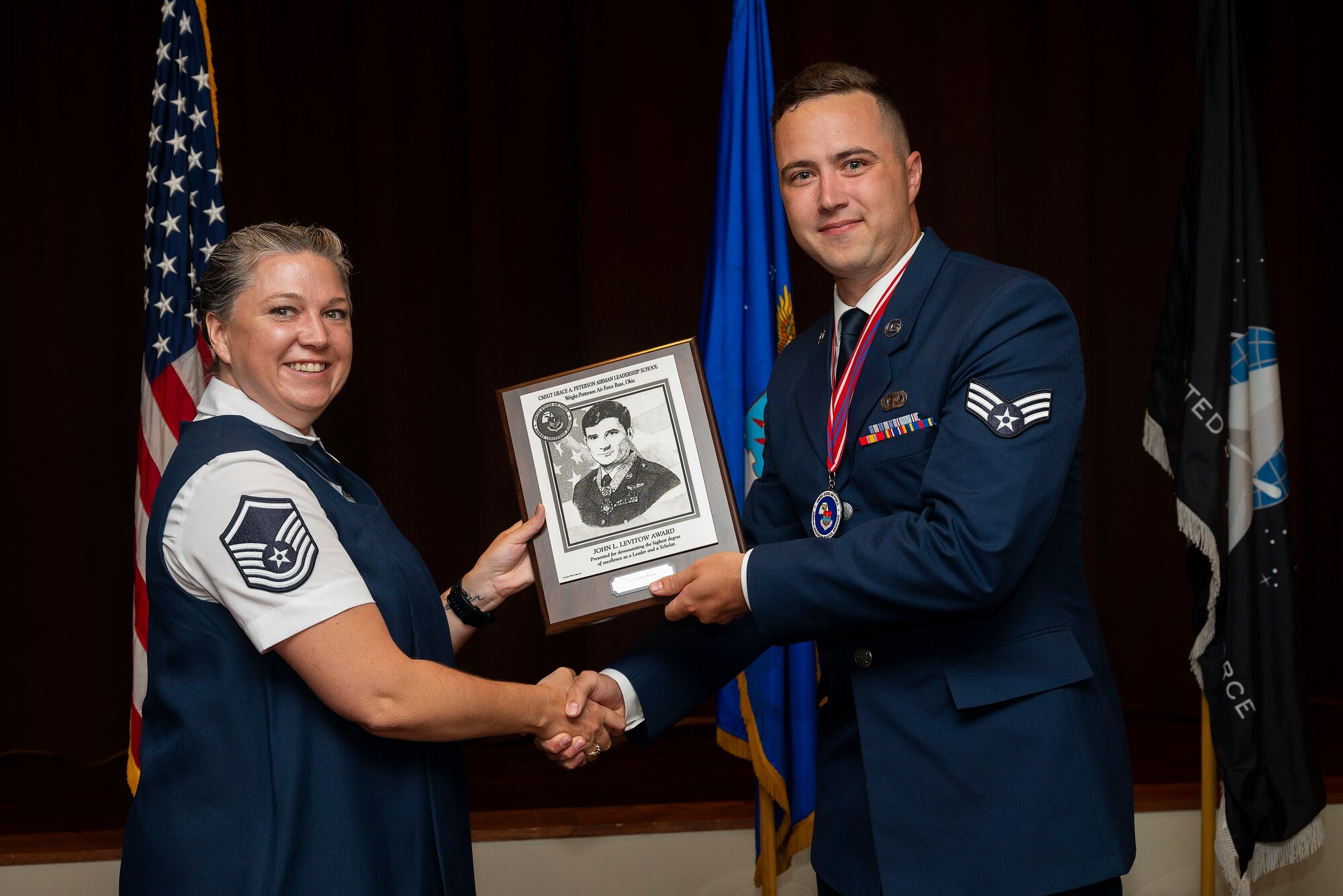 Master Sgt. Dominique Hix, Air Force Sergeants Association, presents Airman Arthur Marais, National Air and Space Intelligence Center, with the John L. Levitow Award at the Chief Master Sgt. Grace A. Peterson Airman Leadership School Class 22-E graduation ceremony, June 16, 2022, at Wright-Patterson Air Force Base, Ohio. The John L. Levitow Award goes to the class’s top graduate. (U.S. Air Force photo by R.J. Oriez)
