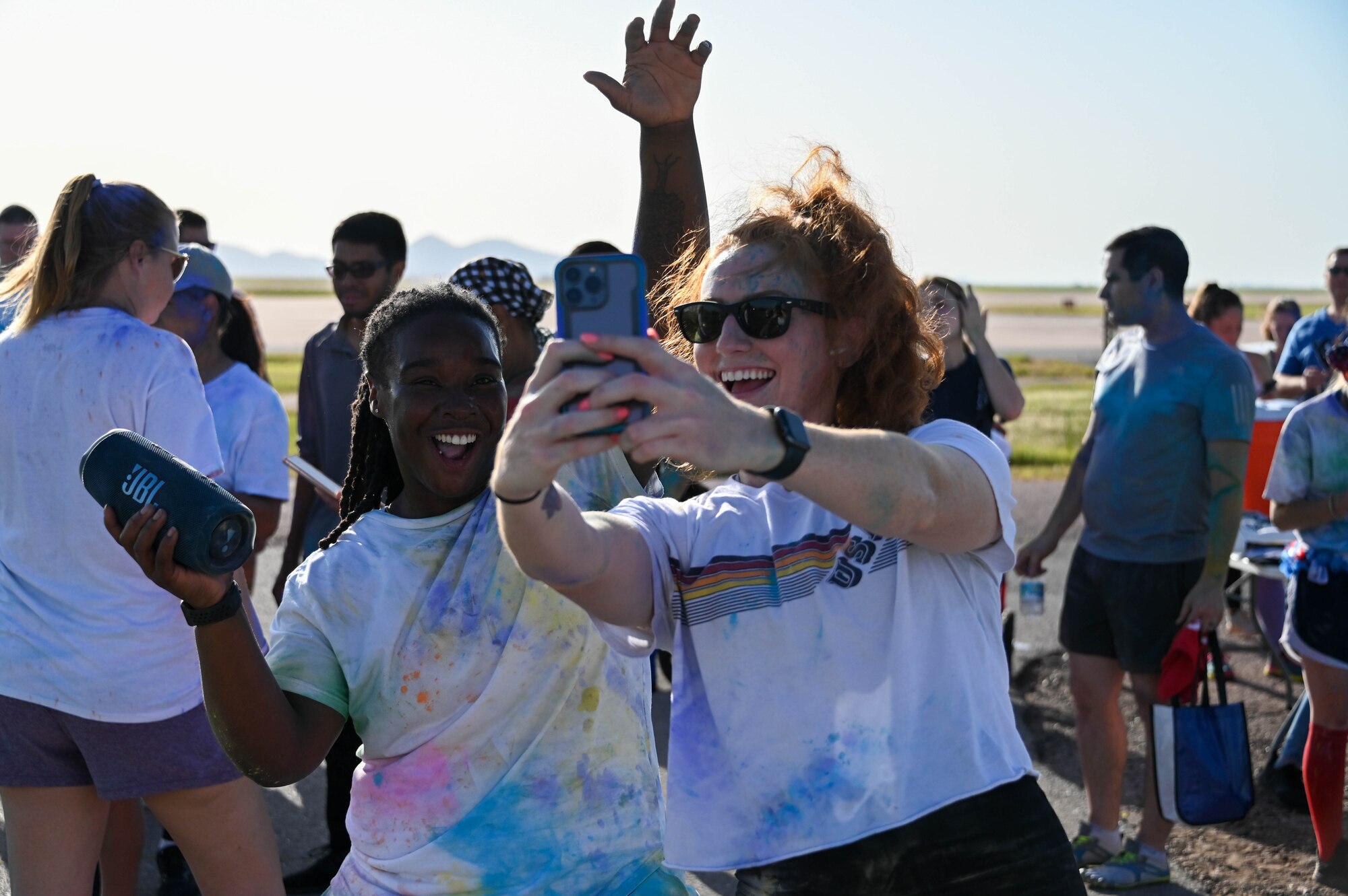 U.S. Air Force 1st Lt. Destini Hamilton (left), 97th Air Mobility Wing executive officer, and 1st Lt. Erica Craft, 97th Comptroller Squadron deputy budget officer, take a photo together at the Pride Month color run at Altus Air Force Base, Oklahoma, June 24, 2022. The first large Pride event was held in New York City on June 28, 1970, on the one-year anniversary of the Stonewall Uprising. (U.S. Air Force photo by Senior Airman Kayla Christenson)