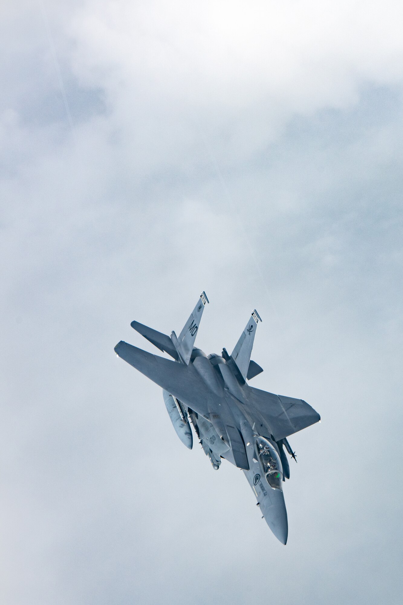 A Singapore jet flies above a cloudy sky.