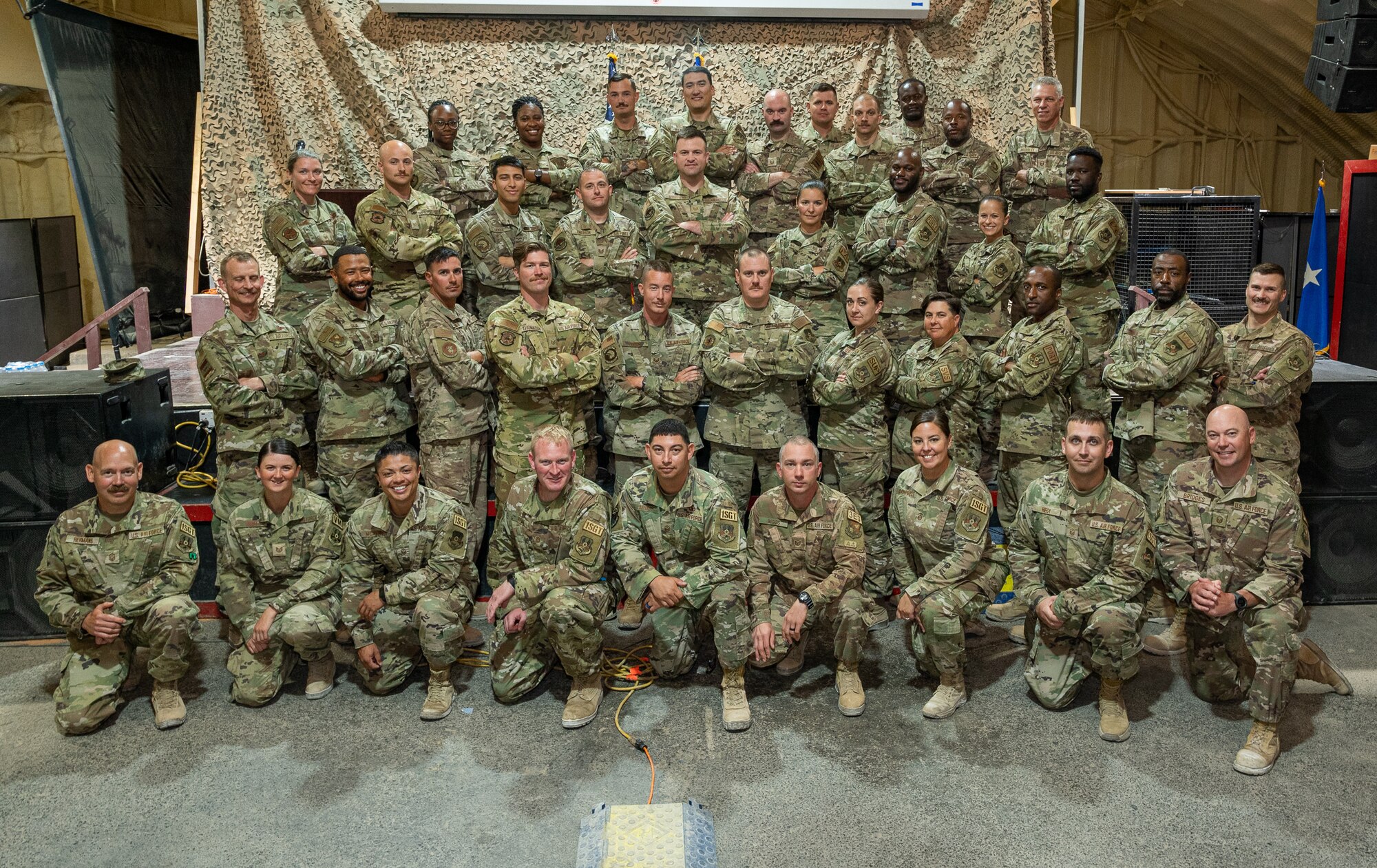 332d Air Expeditionary Wing leadership and First Sergeants pose alongside First Sergeant Symposium graduates at an undisclosed location in Southwest Asia, June 21, 2022. A First Sergeant is the “eyes and ears” of a squadron and serves as a critical link between matters impacting enlisted members and the commander. (U.S. Air Force photo by Master Sgt. Christopher Parr)