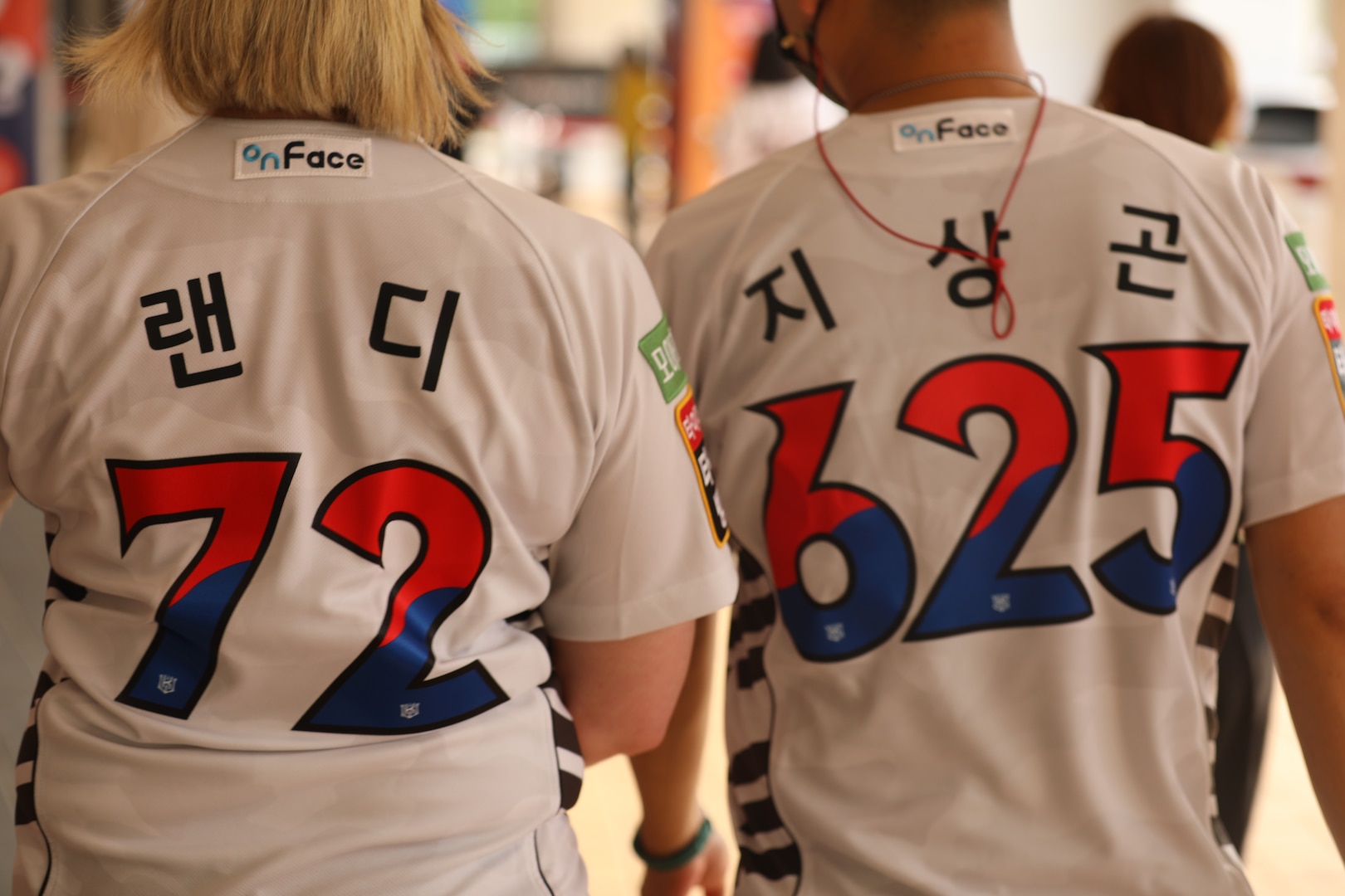 A picture of the back of Lt. Col. Killingsworth's and Capt. (P) Ji's baseball jersey's with the numbers 72 and 625, respectively.