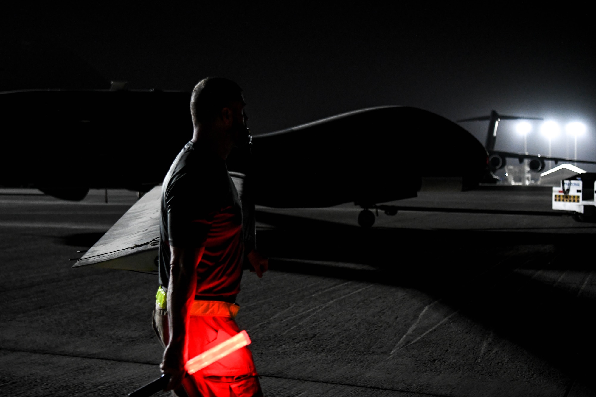 A Northrup Grumman contractor escorts the last U.S. Navy RQ-4 Global Hawk, attached to the Broad Area Maritime Surveillance Demonstrator mission, onto the flight line June 16, 2022, at Al Dhafra Air Base, United Arab Emirates. The Global Hawk training mission at ADAB was originally scheduled to last 6 months but mission effectiveness and reliability led to an extension of the mission, lasting approximately 13 years.