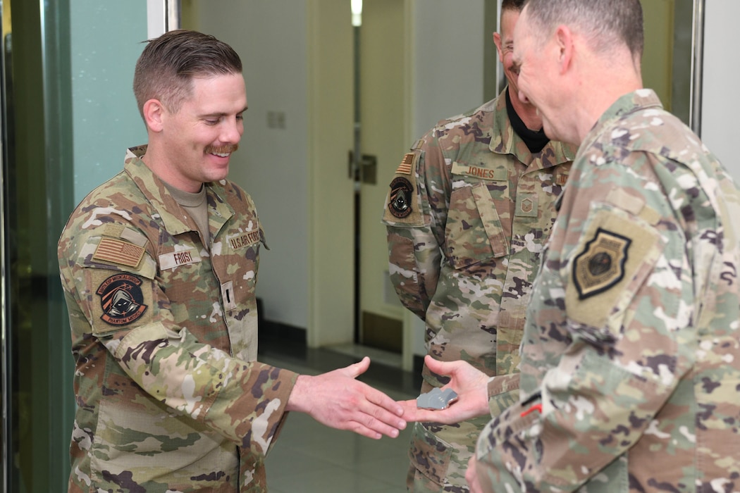 1st Lt. Del Frost, the executive officer of the 380th Expeditionary Medical Squadron, receives a challenge coin from Lt. Gen. Gregory M. Guillot, the Ninth Air Force (Air Forces Central) commander, June 3, 2022 at Al Dhafra Air Base, United Arab Emirates. Frost was recognized for building partnerships with the 380th AEW’s Emirati partners and local, host nation hospitals involved in the Trauma, Burn and Rehabilitative Medicine mission in the UAE.