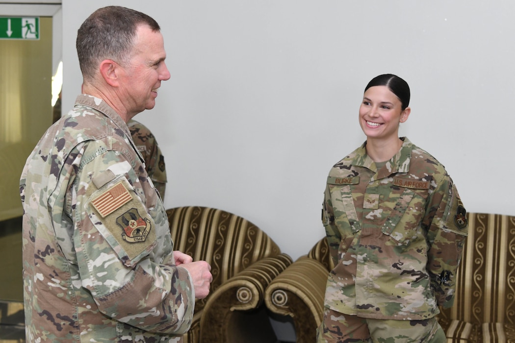 Lt. Gen. Gregory M. Guillot, the Ninth Air Force (Air Forces Central) commander, speaks with Senior Airman Marta Burke, a contracting specialist assigned to the 380th Expeditionary Contracting Squadron, June 3, 2022 at Al Dhafra Air Base, United Arab Emirates. Burke was recognized for her role in successfully managing multiple, critical life support projects for the base construction team.