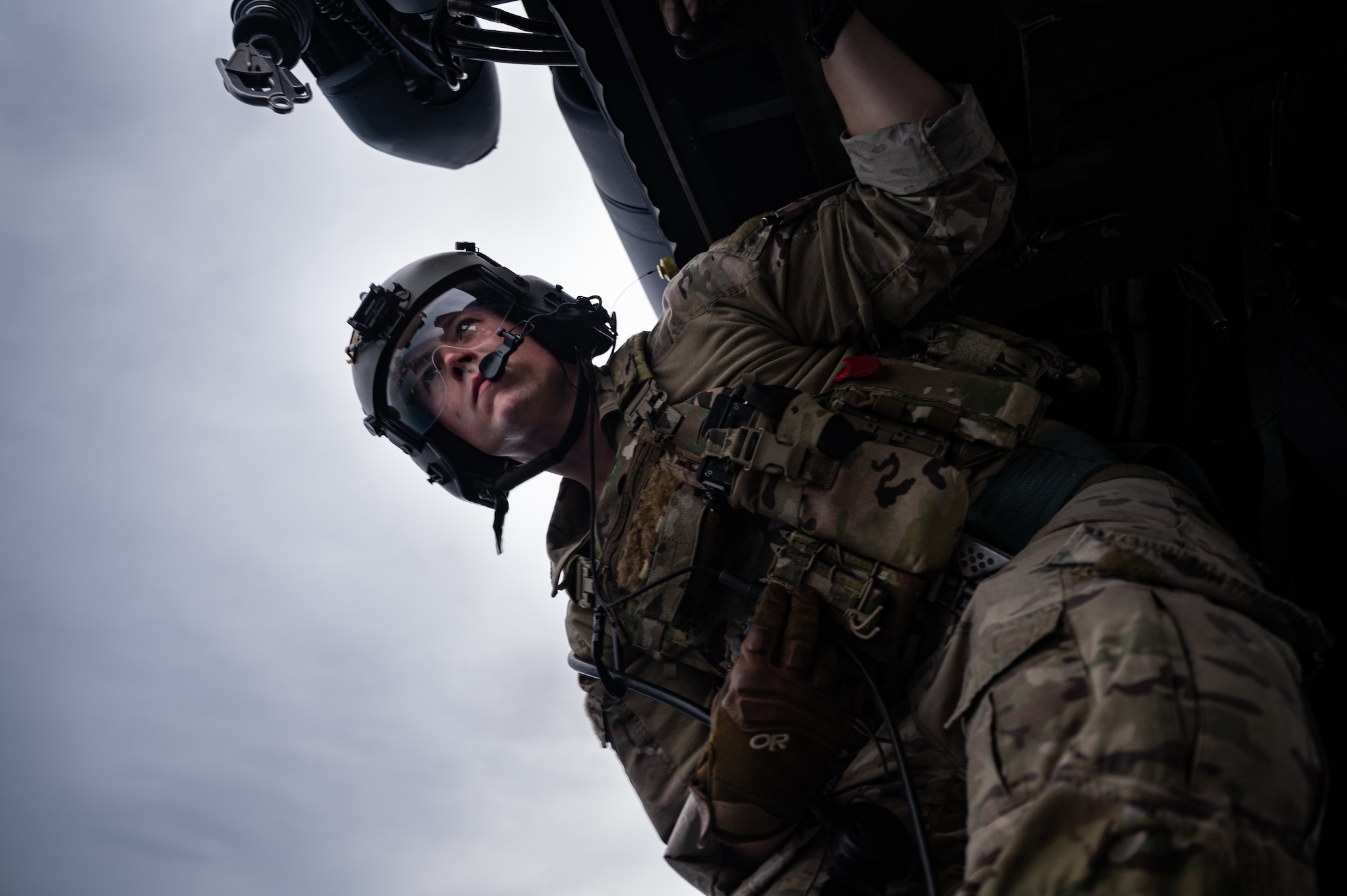 Airman looks out helicopter.