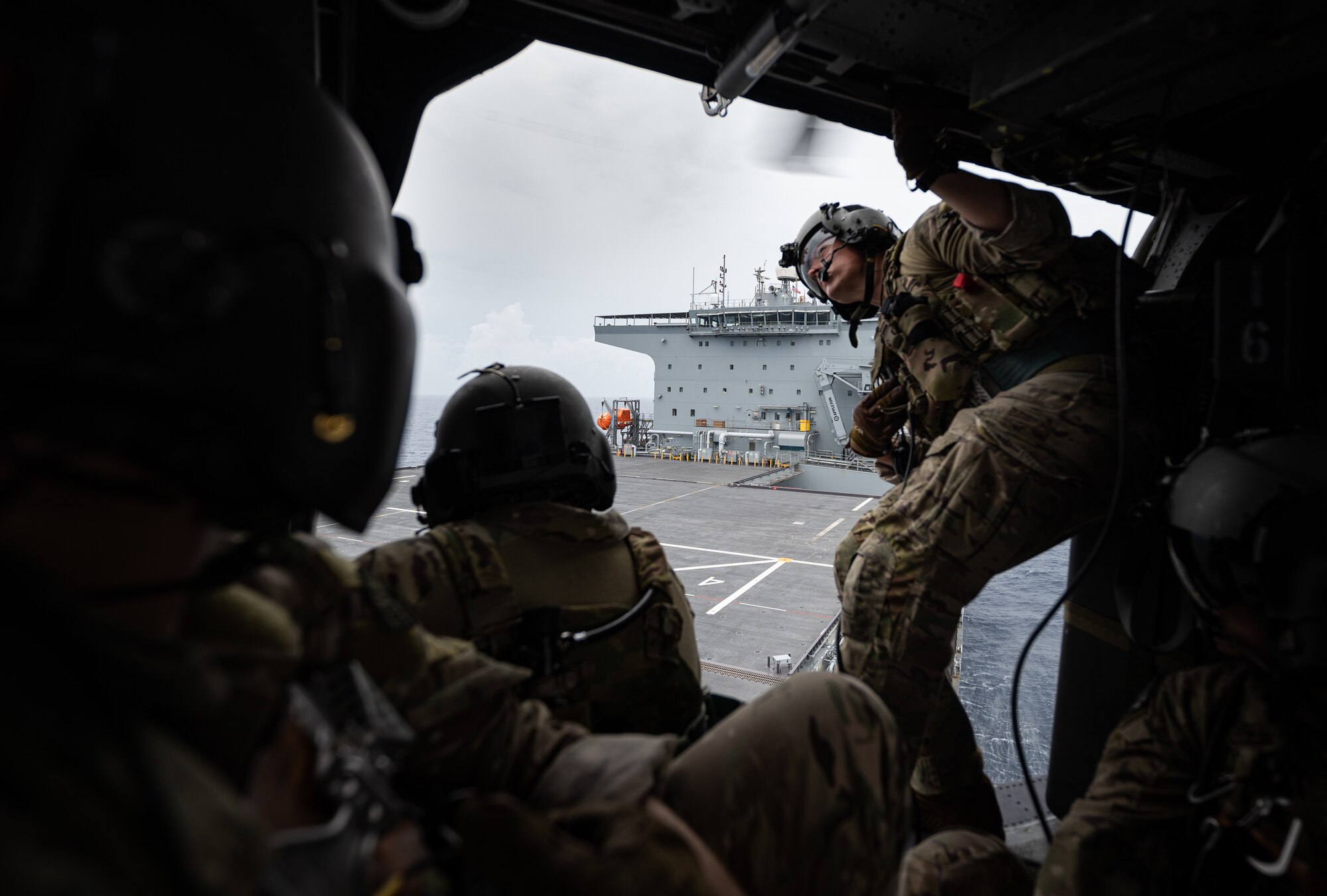 Airman looks out helicopter.