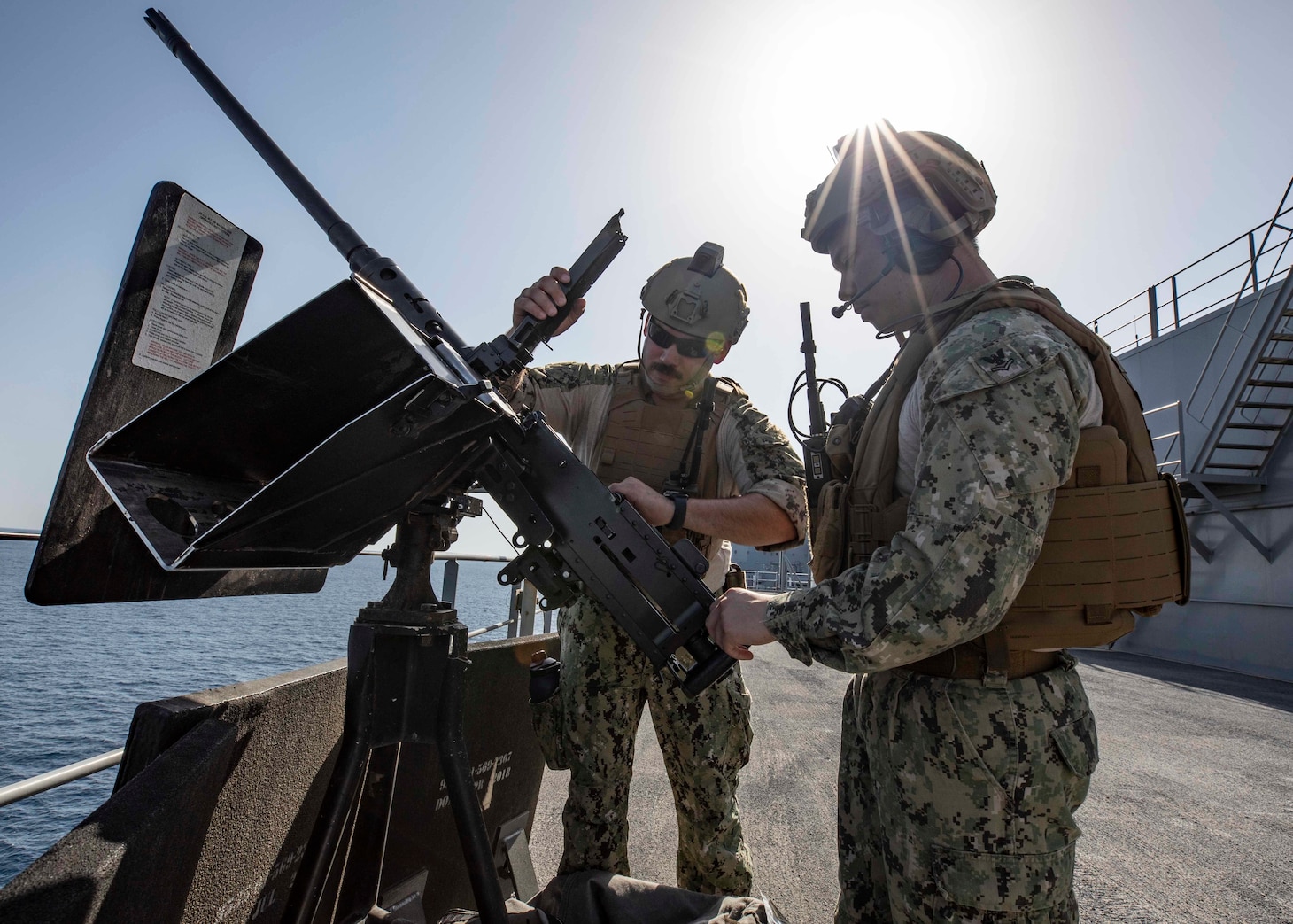 (June 5, 2022) Hospital Corpsman 1st Class Giovanne Farias, left, from Dallas, and Machinist's Mate 2nd Class Bryant Neri, from Temecula, California, conduct a safety check on a .50-caliber machine gun on the Lewis B. Puller-class expeditionary sea base USS Hershel "Woody" Williams (ESB 4) while entering port at Naval Support Activity Souda Bay, Greece, June 5, 2022. Hershel “Woody” Williams is rotationally deployed to the U.S. Naval Forces Africa area of operations, employed by U.S. Sixth Fleet, to defend U.S., allied and partner interests.