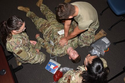 Airman 1st Class Charlie Saulsbury, 185th Air Refueling Wing medical technician, is on the floor while fellow med techs, Staff Sgt. Skylar Casson, Airman 1st Class Colton Seidler and Master Sgt. Perla Solis, practice first aid techniques. The Airmen are training at the Air National Guard Combat Readiness Training Center in Savannah, Georgia.