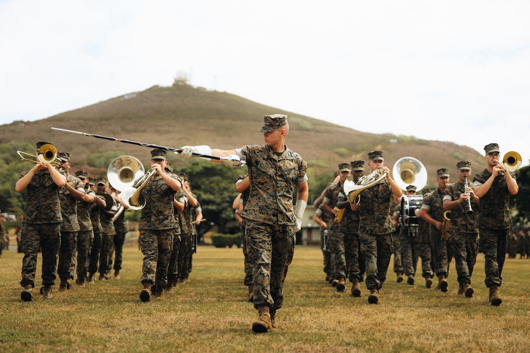 Marines playing instruments walk toward the camera.