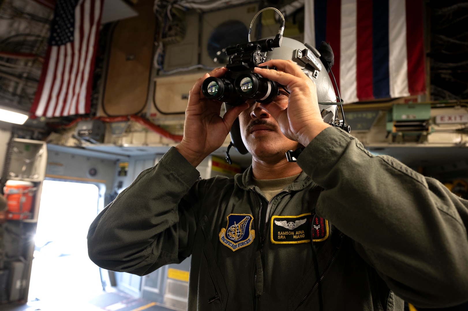 a man with a helmet holds goggles to his eyes.