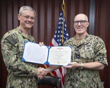 SILVERDALE, Wash. (June 23, 2022) – U.S. Navy Rear Adm. Robert Gaucher, commander, Submarine Group 9, right, presents a Legion of Merit certificate to U.S. Navy Capt. Robert Figgs, departing commanding officer of Trident Refit Facility, Bangor (TRFB), during a change of command ceremony at TRFB. TRFB supports the nation’s strategic deterrence mission by repairing, incrementally overhauling, and modernizing Pacific Fleet strategic ballistic missile submarines during refits. (U.S. Navy photo by Mass Communication Specialist 2nd Class Sarah Christoph/Released)