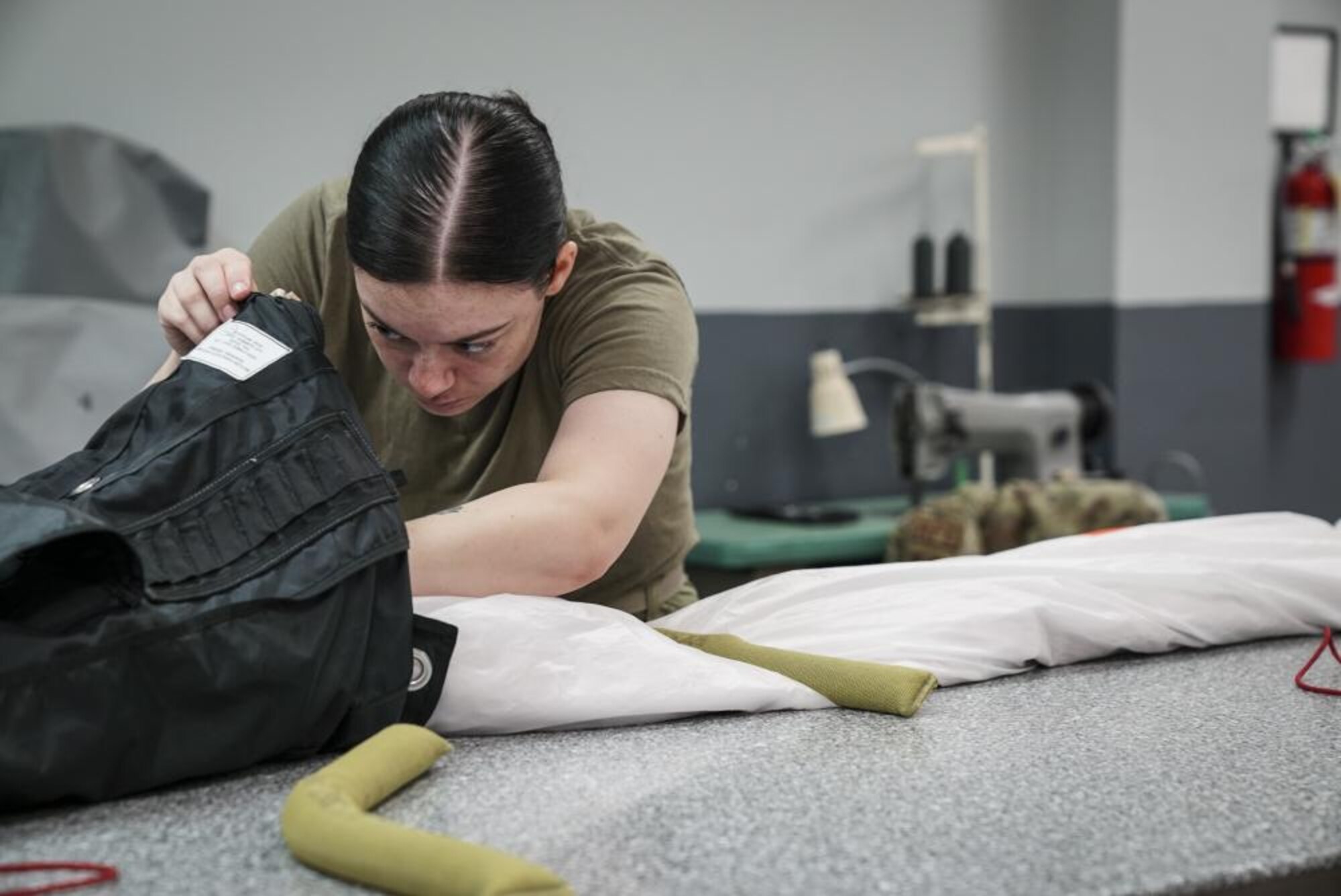 U.S. Air Force Airman Kennedy Salvetti, a 1st Special Operations Support Squadron aircrew flight equipment specialist, packs a low-profile parachute in an ‘S’ fold pattern, at Hurlburt Field, Florida, June 14, 2022.