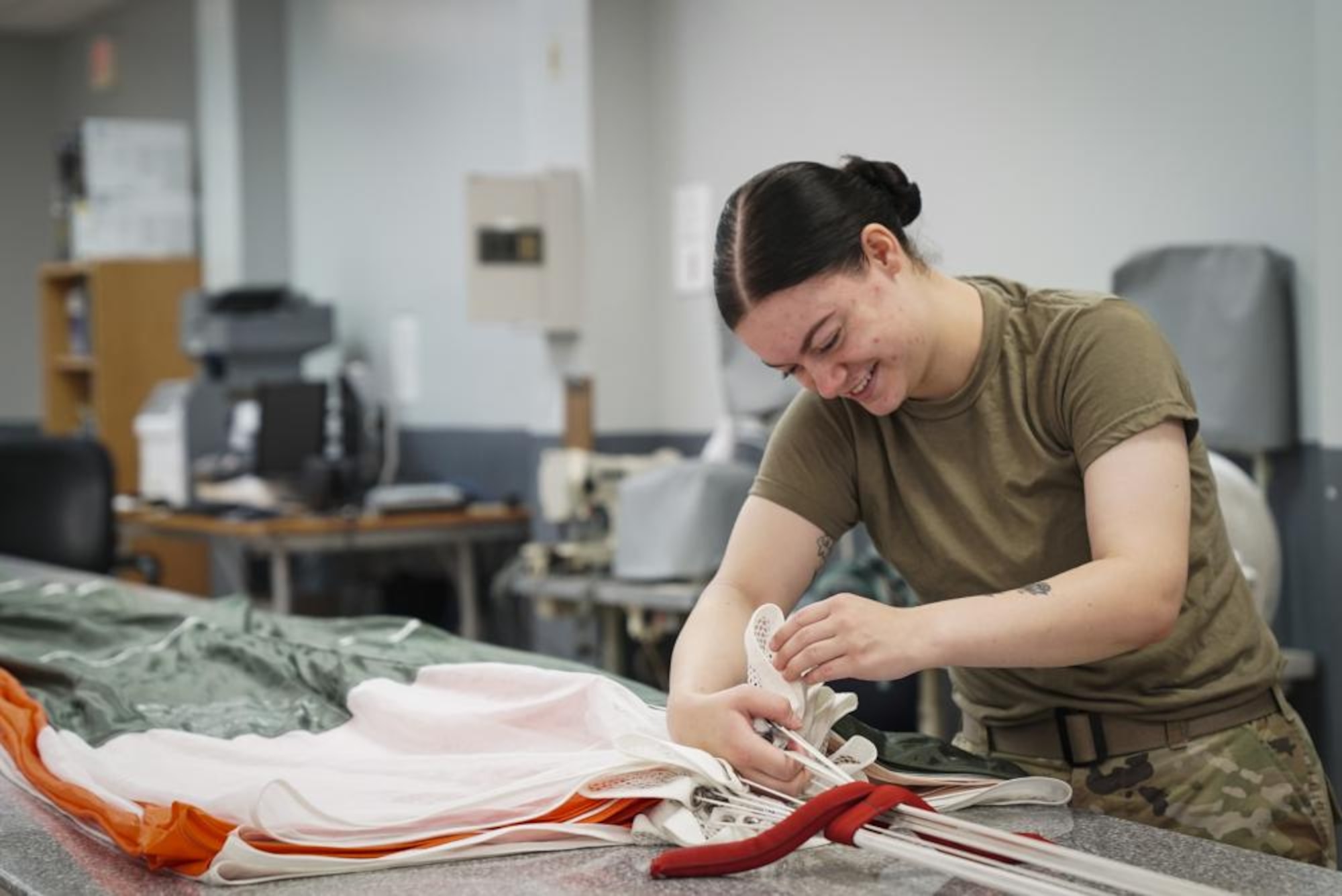 U.S. Air Force Airman Kennedy Salvetti, a 1st Special Operations Support Squadron aircrew flight equipment specialist, counts each fold of a parachute ensuring there are ten folds on each side, at Hurlburt Field, Florida, June 14, 2022.