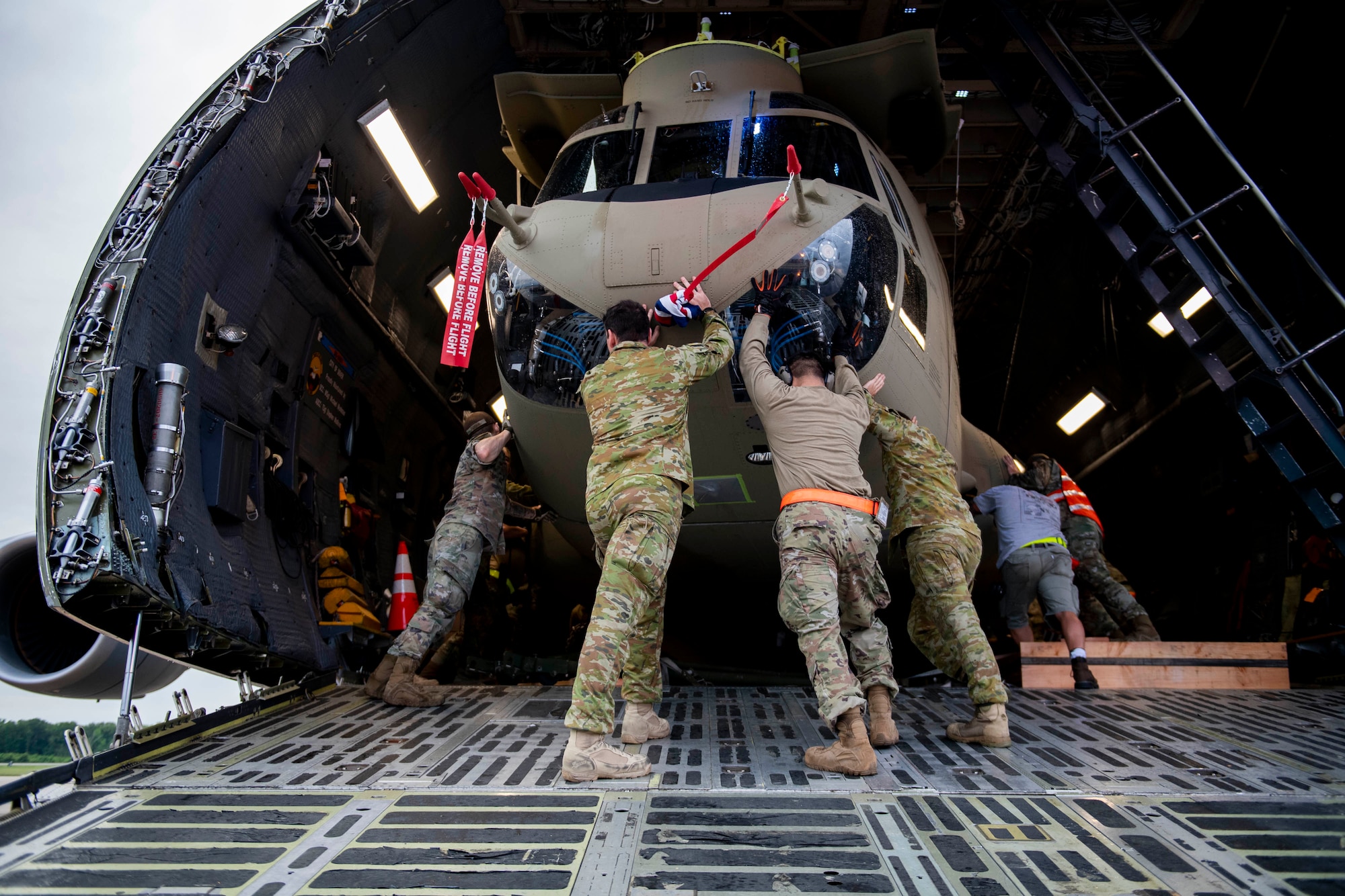 Australian Army soldiers and 436th Aerial Port Squadron ramp services personnel load a CH-47F Chinook helicopter onto a C-5M Super Galaxy during a foreign military sales mission at Dover Air Force Base, Delaware, June 16, 2022. The U.S. and Australia maintain a robust relationship that serves as an anchor for peace and stability in the Indo-Pacific region and around the world. Due to its strategic location, Dover AFB supports approximately $3.5 billion worth of foreign military sales annually. (U.S. Air Force photo by Tech. Sgt. J.D. Strong II)