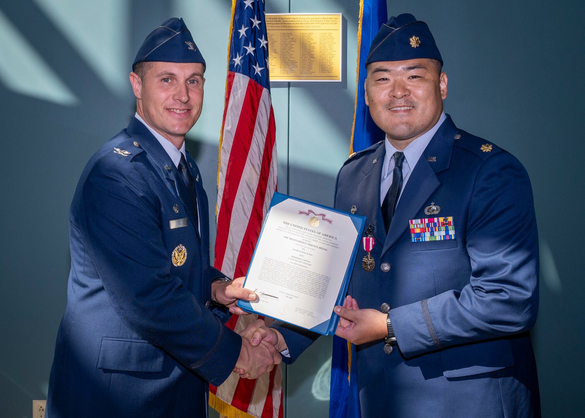 Col. Lucas Teel, left, 4th Fighter Wing commander, presents Maj. Samuel Han, outgoing 4th Comptroller Squadron commander, with the Meritorious Service Medal at Seymour Johnson Air Force Base, North Carolina, June 24, 2022.