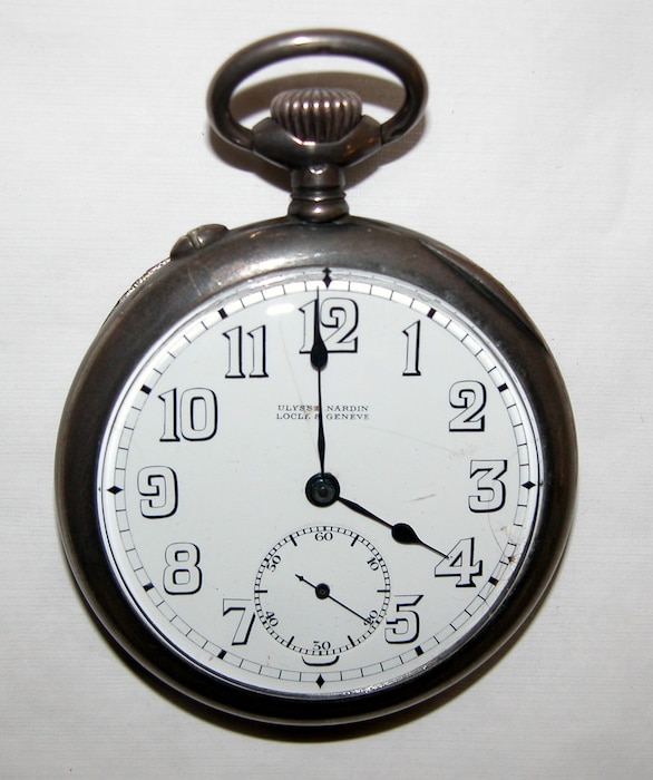 Open watch face of a white and silver pocket watch
