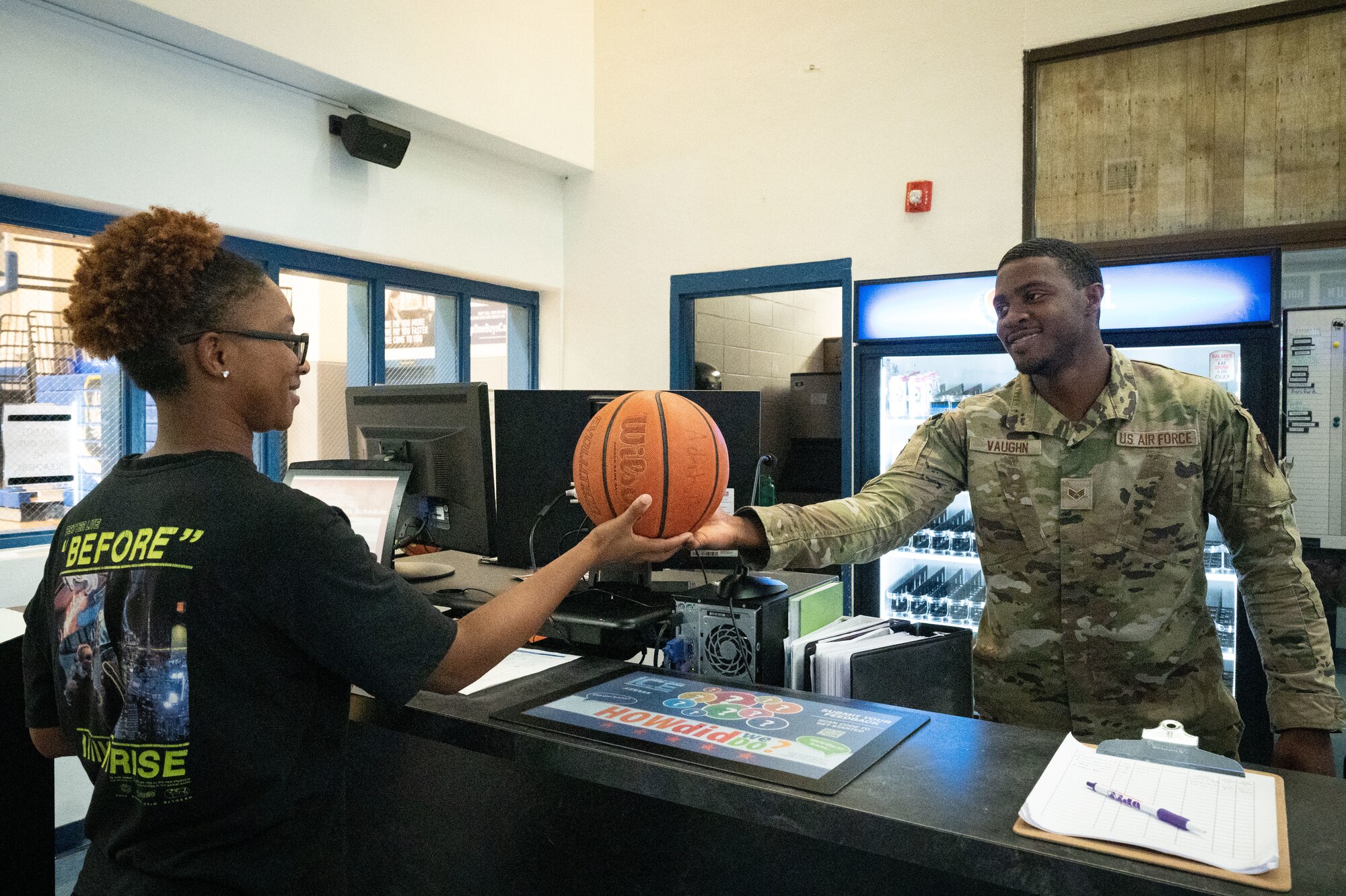 U.S. Air Force Senior Airman Richard Vaughn, a 1st Special Operations Force Support Squadron fitness center apprentice, hands a customer a basketball at Hurlburt Field, Florida, June 16, 2022.