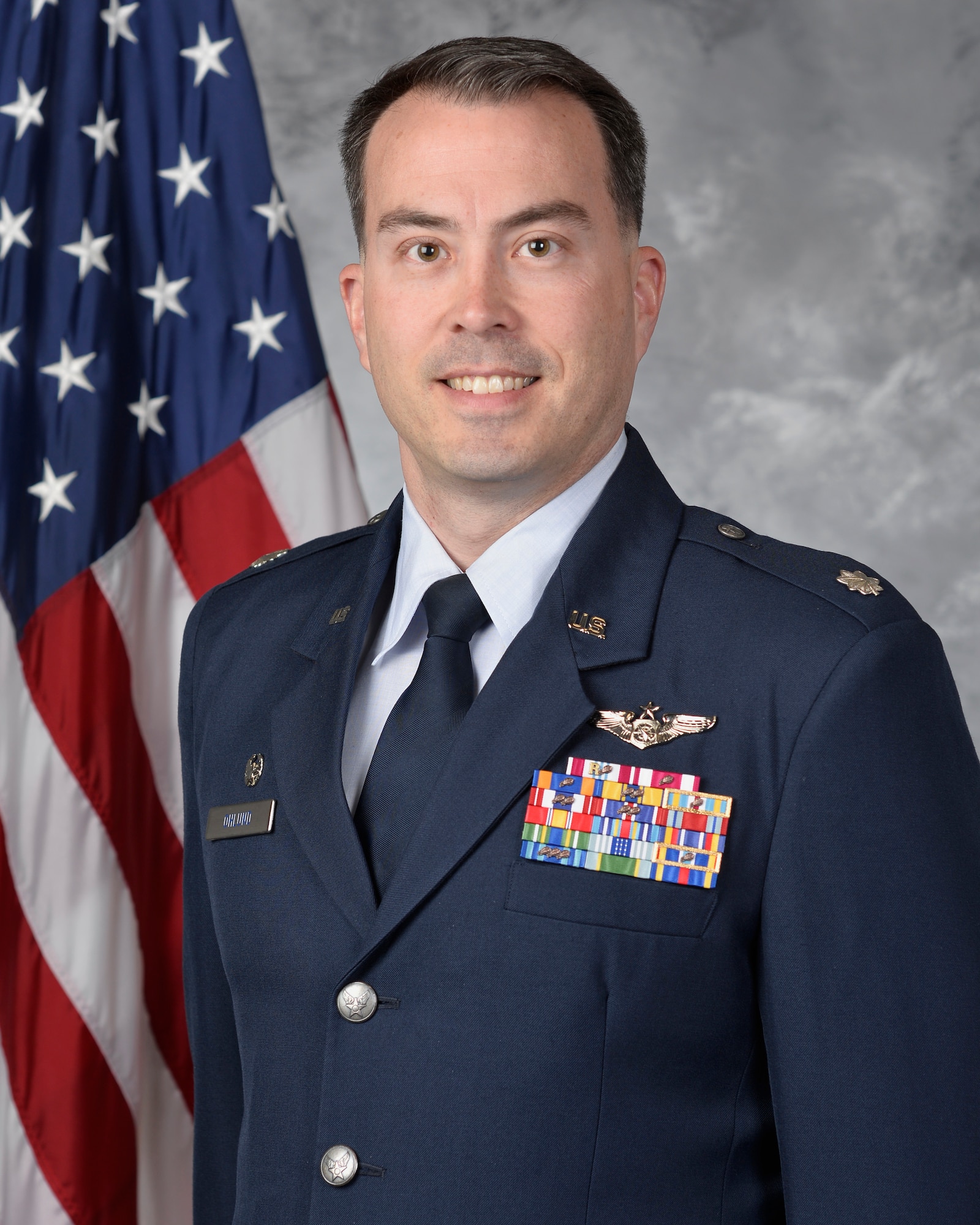 photo of USAF Airmen in service dress with US flag in background