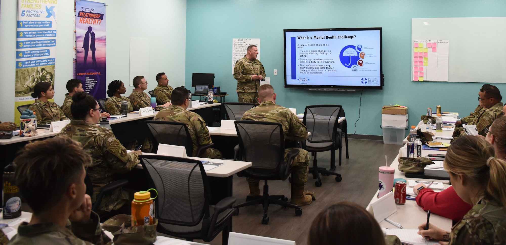 Pictured above is a group of Airmen listening to a brief in a classroom.
