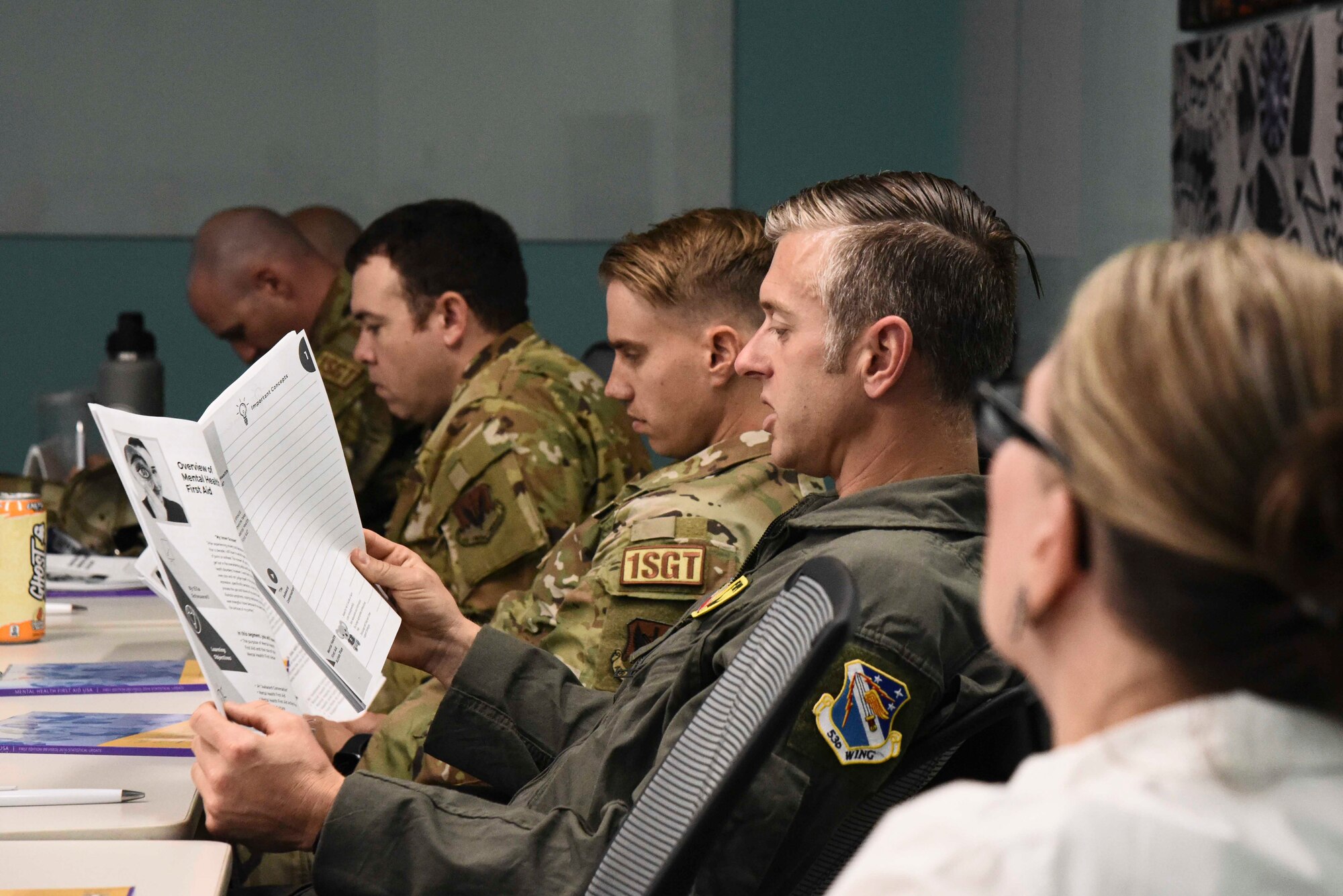 Pictured above is an Airman reading from a book in a classroom.