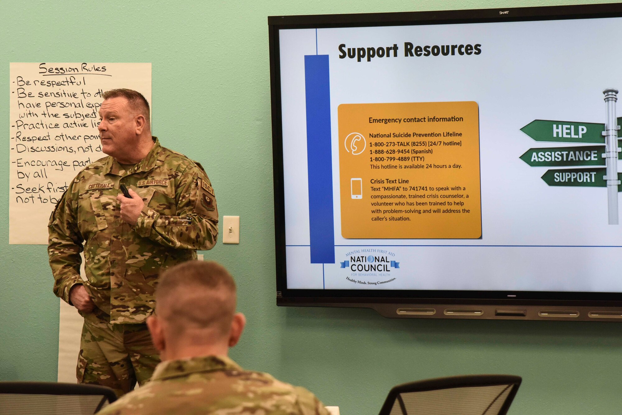 Pictured above is an Airman standing in front of a tv with a slideshow.