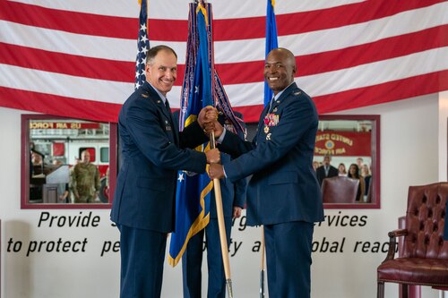 Col. Phelemon Williams, right, outgoing 436th Mission Support Group commander, relinquishes command after handing the guidon to Col. Matt Husemann, left, 436th Airlift Wing commander, during a change of command ceremony held at the base fire station on Dover Air Force Base, Delaware, June 27, 2022. Williams relinquished command of the 436th MSG to Col. Jason Holcomb, previously the Headquarters Air Force Materiel Command budget director at Wright-Patterson Air Force Base, Ohio. (U.S. Air Force photo by Senior Airman Faith Schaefer)