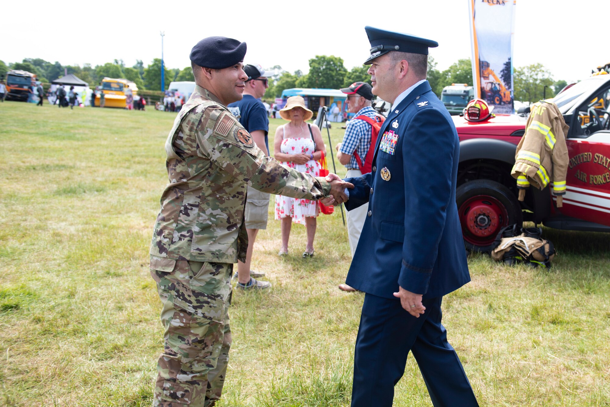 U.S. Air Force Col. Brian Filler, right, 501st Combat Support Wing commander, greets Master Sgt. Christian Navarro-Salazar, left, 423rd Security Forces Squadron section chief of resources and logistics, during the Cambridgeshire County Day at the Newmarket July Course, England, June 23, 2022. The County Day was an opportunity to celebrate Cambridgeshire and Her Majesty The Queen’s Platinum Jubilee. (U.S. Air Force photo by Senior Airman Jennifer Zima)