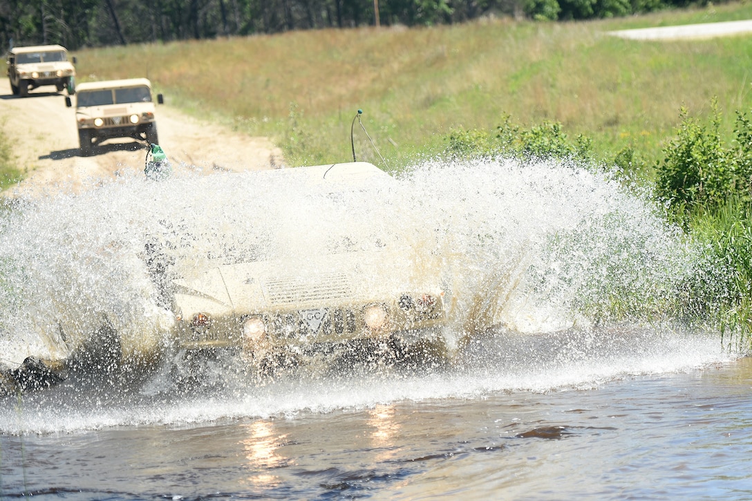 U.S. Army Reserve Soldiers navigate Humvees through water passings during a convoy mission at the Spartan Warrior Three exercise at Fort McCoy, Wisconsin.