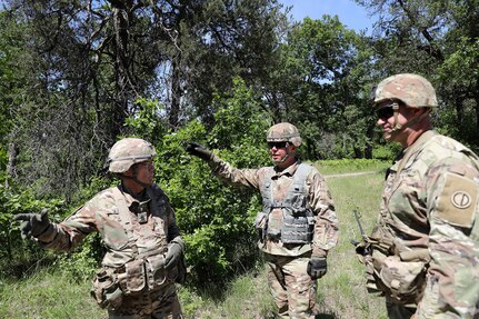 Cmd. Sgt. Maj. Steven Slee, left, 85th U.S. Army Reserve Support Command, talks with two observer coach/trainers during convoy operations.