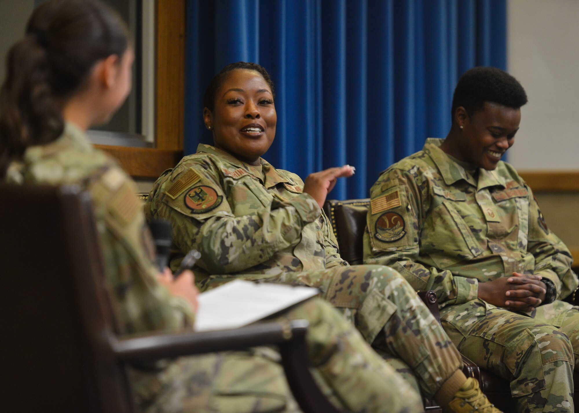 A group of women talk on stage.