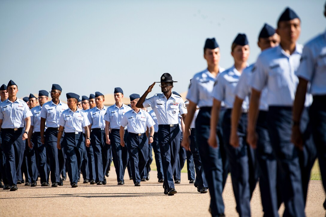 Guardians walk in formation outside, as one salutes.