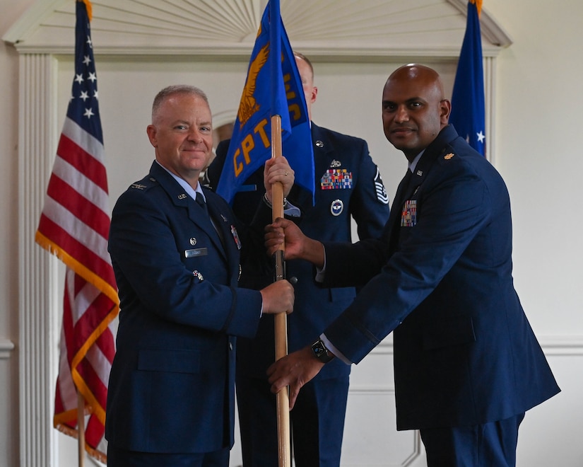 Maj. Trivendhiran Pillai, right, accepts command of the 316th Comptroller Squadron from Col. Tyler Schaff, 316th Wing and  installation commander, during a change of command ceremony at Joint Base Andrews, Md., June 27, 2022.