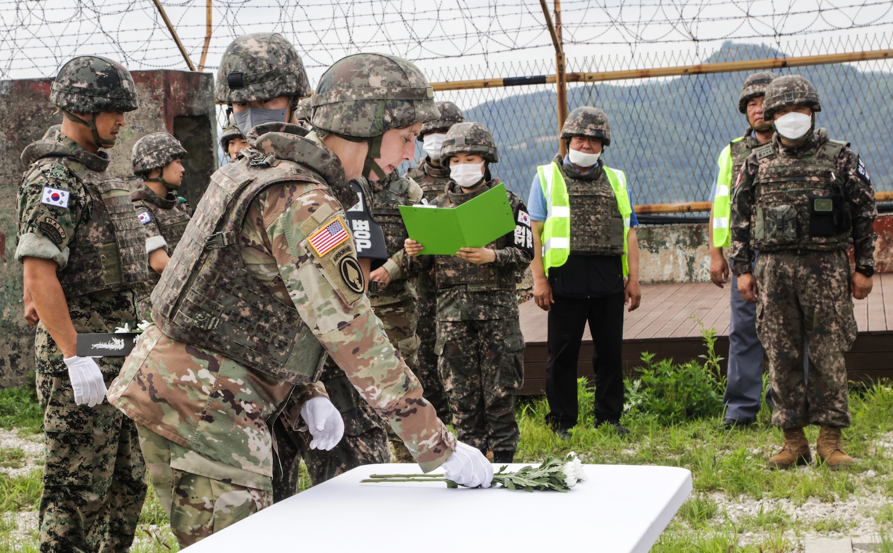 Command Sgt. Maj. JoAnn Naumann, command senior enlisted leader with Special Operations Command Korea, places a flower in honor of the fallen Soldier who gave their life defending Arrow Head Ridge 281, at South Korea, June 22, 2022.