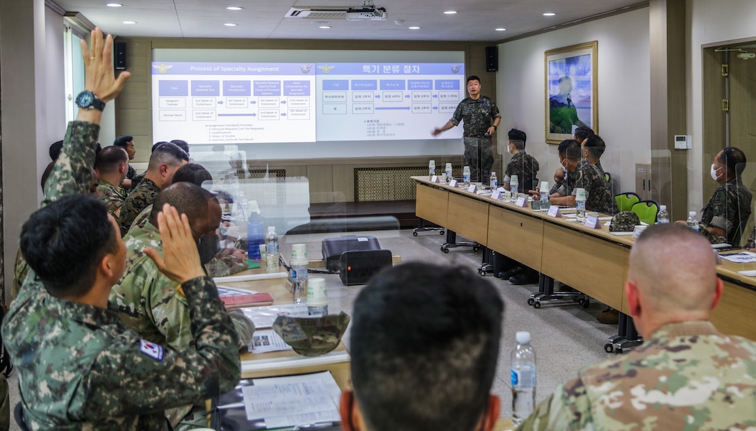 Command Sgt. Major Yong-kyu Lee, senior enlisted advisor for the Combined Forces Command Republic of Korea forces, raises his hand to ask a question to Command Master Sgt. Seong-ryeul Yoon, ROK Air Force Chief Master Sgt. Seong-ryeul Yoon during a brief on education and training systems at South Korea, June 21, 2022.