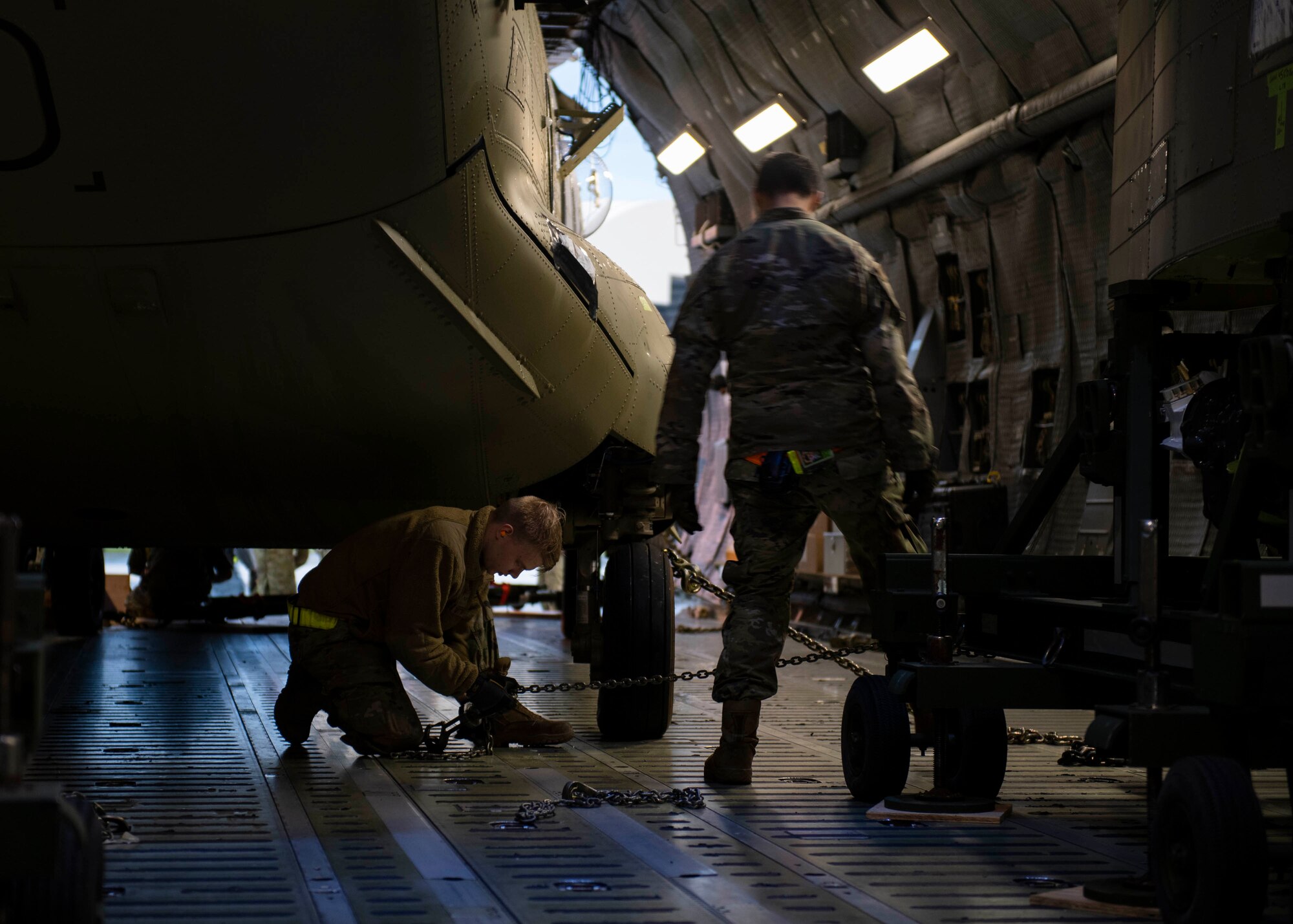 436th Aerial Port Squadron ramp services personnel secure a CH-47F Chinook helicopter in a C-5M Super Galaxy during a foreign military sales mission at Dover Air Force Base, Delaware, June 16, 2022. The U.S. and Australia maintain a robust relationship that serves as an anchor for peace and stability in the Indo-Pacific region and around the world. Due to its strategic location, Dover AFB supports approximately $3.5 billion worth of foreign military sales annually. (U.S. Air Force photo by Tech. Sgt. J.D. Strong II)