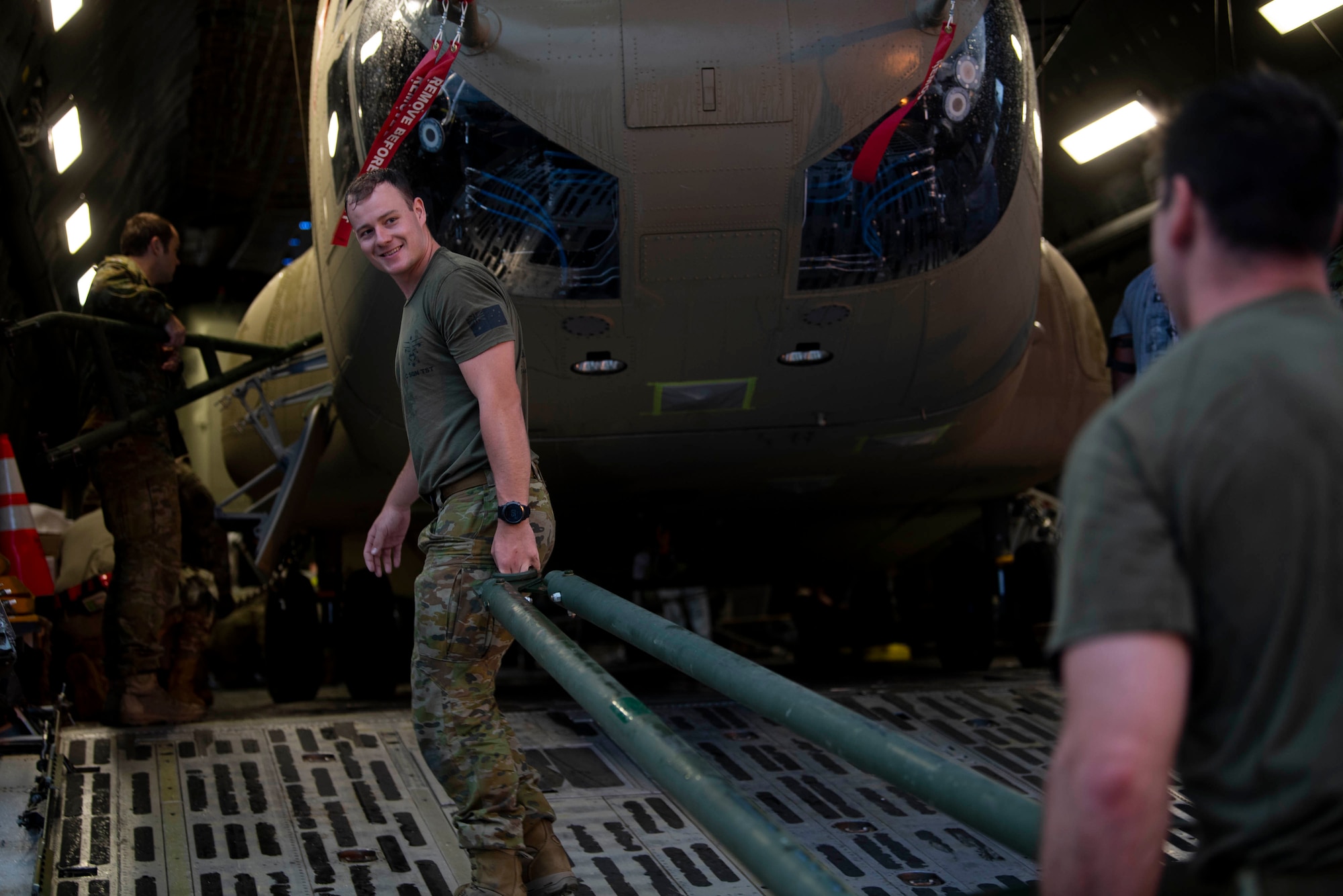 Australian Army soldiers load a CH-47F Chinook helicopter tow bar onto a C-5M Super Galaxy during a foreign military sales mission at Dover Air Force Base, Delaware, June 16, 2022. The U.S. and Australia maintain a robust relationship that serves as an anchor for peace and stability in the Indo-Pacific region and around the world. Due to its strategic location, Dover AFB supports approximately $3.5 billion worth of foreign military sales annually. (U.S. Air Force photo by Tech. Sgt. J.D. Strong II)