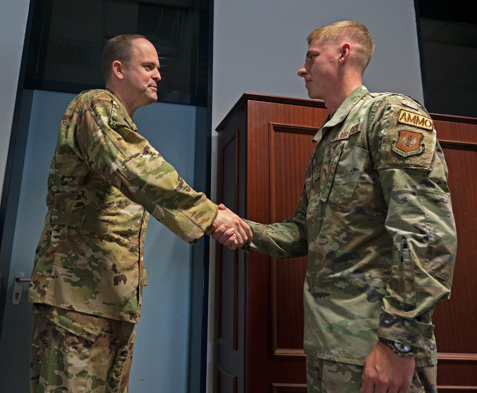 U.S. Air Force Col. Denny Davies, 86th Airlift Wing vice commander, congratulates Airman 1st Class Riston Mais, 86th Munitions Squadron conventional maintenance technician, for earning Airlifter of the Month at Ramstein Air Base, Germany, June 16, 2022.