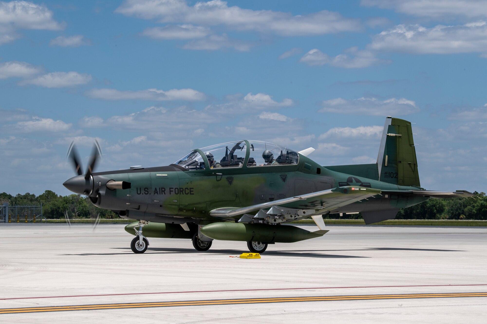 Craig Fisher, 81st Fighter Squadron supervisory instructor pilot, parks an AT-6E Wolverine with a Colombian air force pilot at Avon Park Air Force Range, Florida, May 10, 2022. The U.S. Air Force partnered with Colombia, Tunisia, Nigeria, and Thailand to co-develop tactics, techniques and procedures to combat violent extremist organizations while demonstrating the capabilities of the Airborne Extensible Relay Over-Horizon Network. (U.S. Air Force photo by Airman 1st Class Deanna Muir)