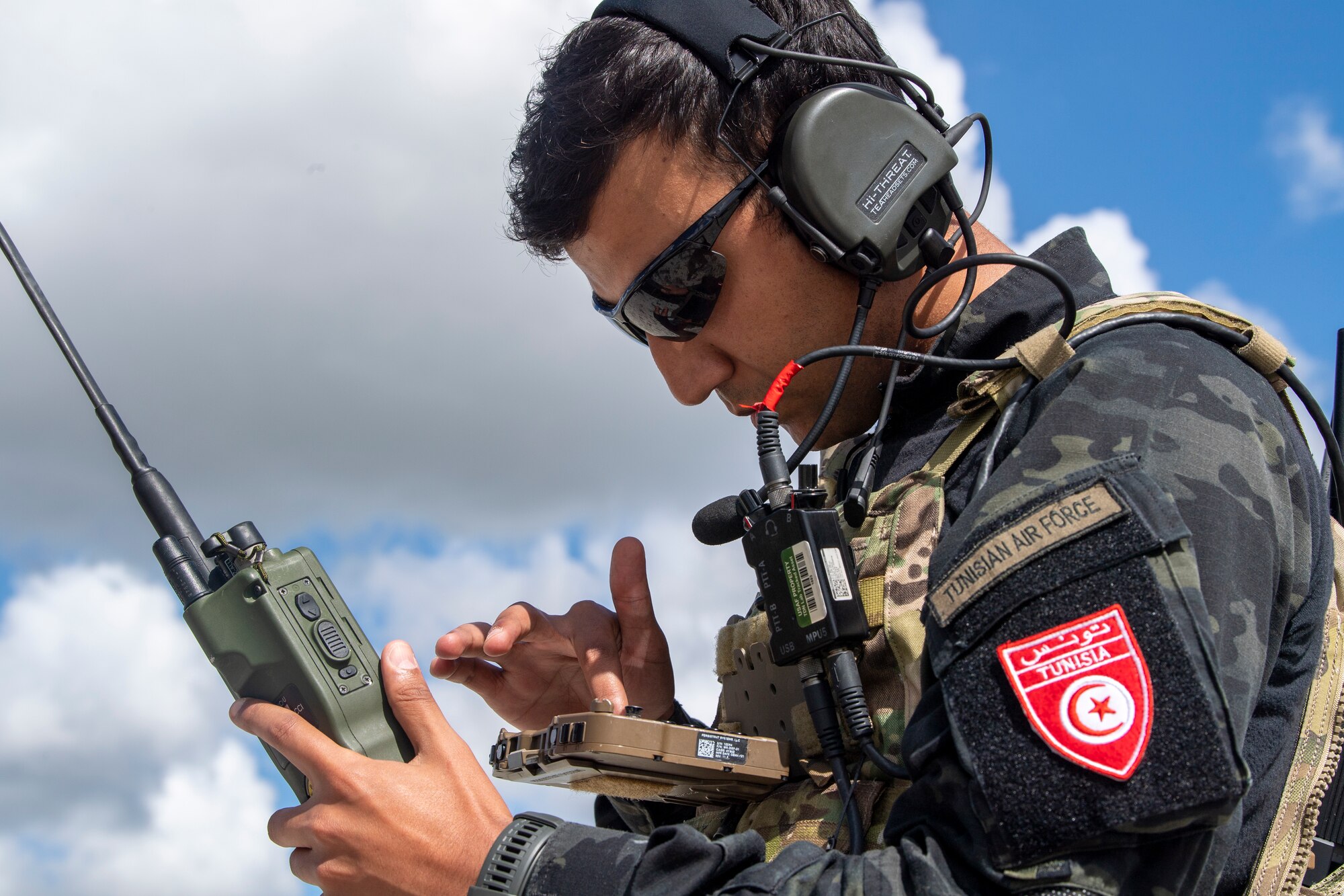 Tunisian air force 1st Lt. Hsan Gabtni, joint terminal attack controller, communicates with U.S. and Tunisian Air Force pilots via the Airborne Extensible Relay Over-Horizon Network at Avon Park Air Force Range, Florida, May 12, 2022. The U.S. Air Force partnered with Colombia, Tunisia, Nigeria, and Thailand to co-develop tactics, techniques and procedures to combat violent extremist organizations while demonstrating the capabilities of the Airborne Extensible Relay Over-Horizon Network. (U.S. Air Force photo by Airman 1st Class Deanna Muir)