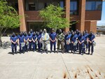 Coast Guard Academy Commandant of Cadets Capt. Art Ray , stands with a group of 1/c cadets dressed in Chemical, Biological, Radiological, and Nuclear (CBRN) personal protective equipment (PPE) during pre-graduation week, May 2022. The Coast Guard Office of Specialized Capabilities coordinated this inaugural training at the academy where members of the Special Missions Training Center taught cadets how to recognize CBRN threats and properly wear PPE equipment.