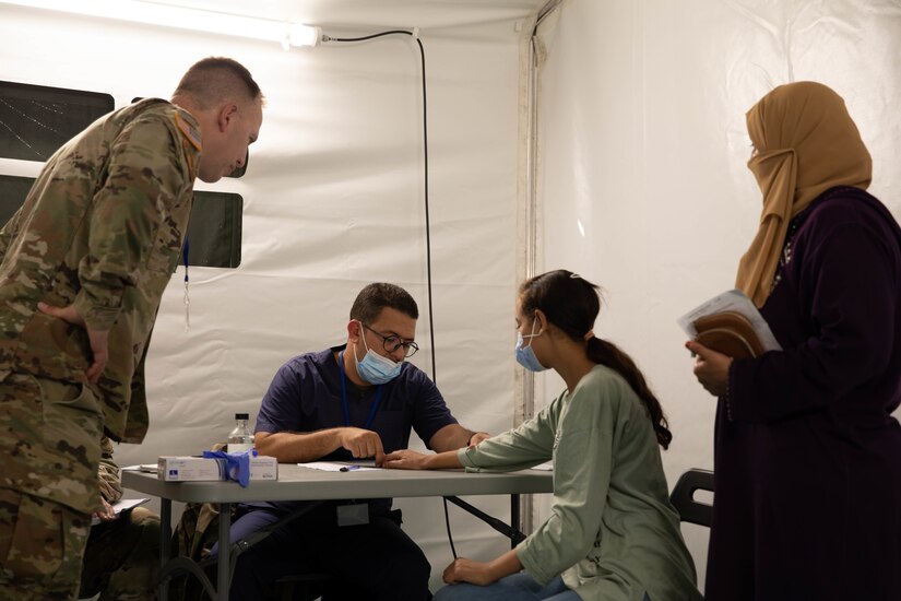 U.S. Army Cpt. Bryan Wheaton and a Royal Moroccan Army physician assesses the medical condition of a Moroccan civilian  at the Humanitarian Civic Assistance (HCA) center in Taliouine, Morocco, June 21, 2022, during African Lion 22.
