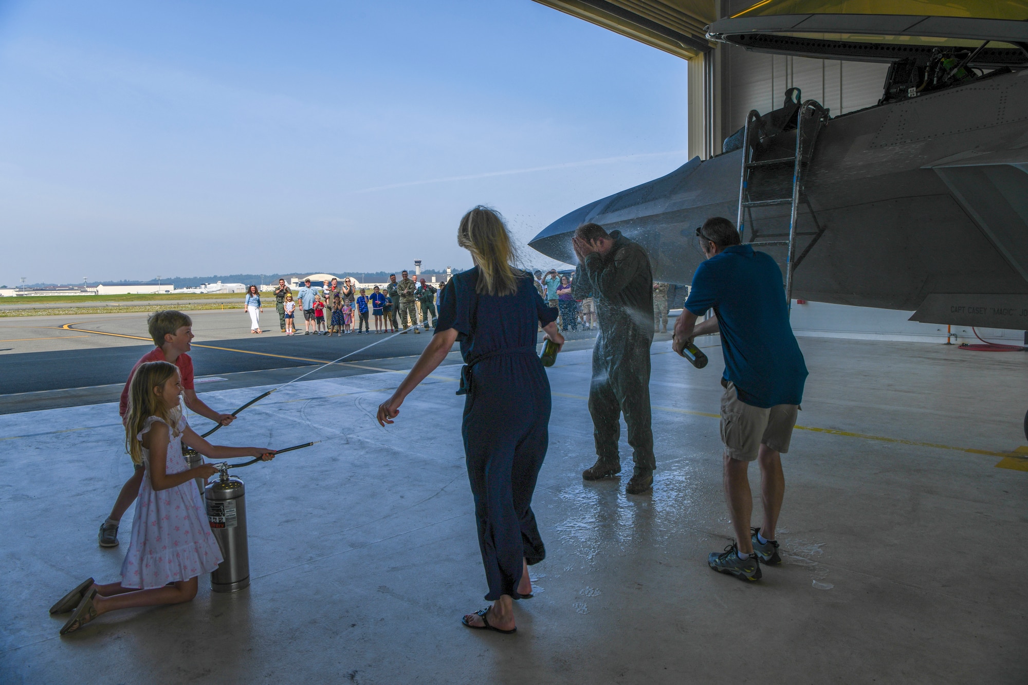 Col. Jonathan Gration Jr., 477th Fighter Group commander, soaked by his family members after arriving from his fini flight, June 24, 2022, Joint Base Elmendorf-Richardson, Alaska. He is currently the longest flying F-22 pilot in the Air Force. (U.S. Air Force photo by Staff Sgt. Melissa Estevez)