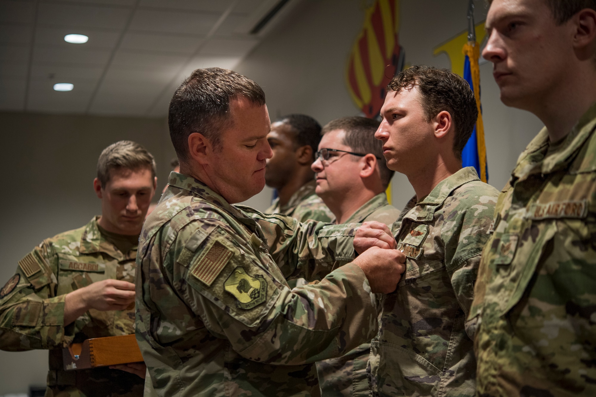 U.S. Air Force Col. Chris Richardson, 347th Rescue Group commander, pins medals on a line of Airmen during an awards ceremony at Moody Air Force Base, Georgia, May 31, 2022. During the ceremony, Moody leadership presented three Bronze Star Medals, 12 single event Air Medals and more than 18 Air Force Commendation Medals with combat devices, and 21 Afghanistan Campaign and Humanitarian Service Medals to the Flying Tigers in attendance. (U.S. Air Force photo by Andrea Jenkins)