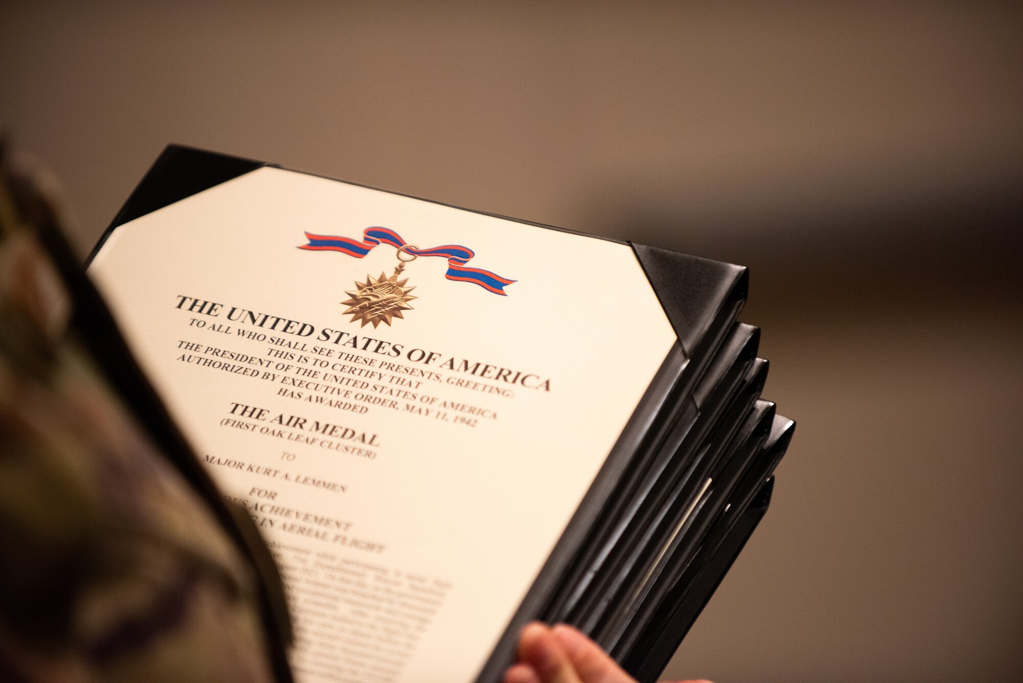 U.S. Air Force Capt. Nick Accardi, 71st Rescue Squadron, holds decoration certificates during an awards ceremony at Moody Air Force Base, Georgia, May 31, 2022. During the ceremony, Moody leadership presented three Bronze Star Medals, 12 single event Air Medals and more than 18 Air Force Commendation Medals with combat devices, and 21 Afghanistan Campaign and Humanitarian Service Medals to the Flying Tigers in attendance. (U.S. Air Force photo by Airman 1st Class Courtney Sebastianelli)