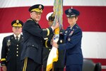 A female military leader speaks at a ceremony.