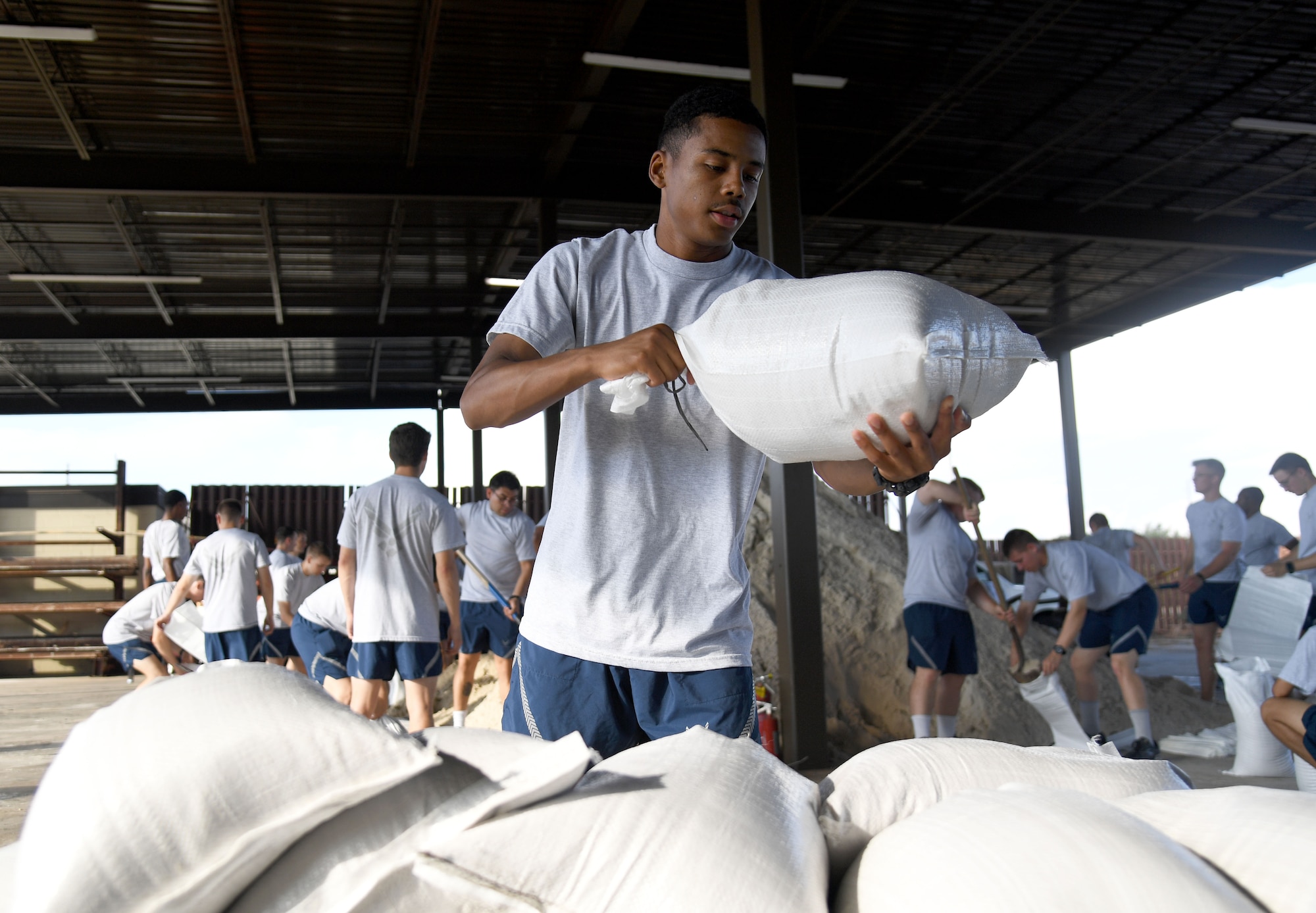 U.S. Air Force Airman Basic Jerimiah Augustine, 338th Training Squadron student, stacks sand bags in preparation for the 2022 hurricane season at Keesler Air Force Base, Mississippi, June 27, 2022. Over 40 Airmen from the 338th TRS assisted the 81st Civil Engineer Squadron with filling more than 2500 sand bags. Hurricane season runs from June 1 through November 30. (U.S. Air Force photo by Kemberly Groue)