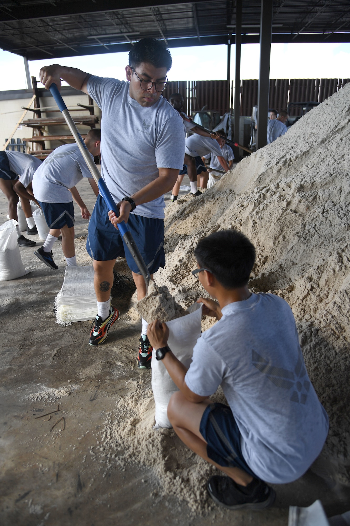 U.S. Air Force Airmen 1st Class Eric Velasco and Steven Esteves, 338th Training Squadron students, fill sand bags in preparation for the 2022 hurricane season at Keesler Air Force Base, Mississippi, June 27, 2022. Over 40 Airmen from the 338th TRS assisted the 81st Civil Engineer Squadron with filling more than 2500 sand bags. Hurricane season runs from June 1 through November 30. (U.S. Air Force photo by Kemberly Groue)