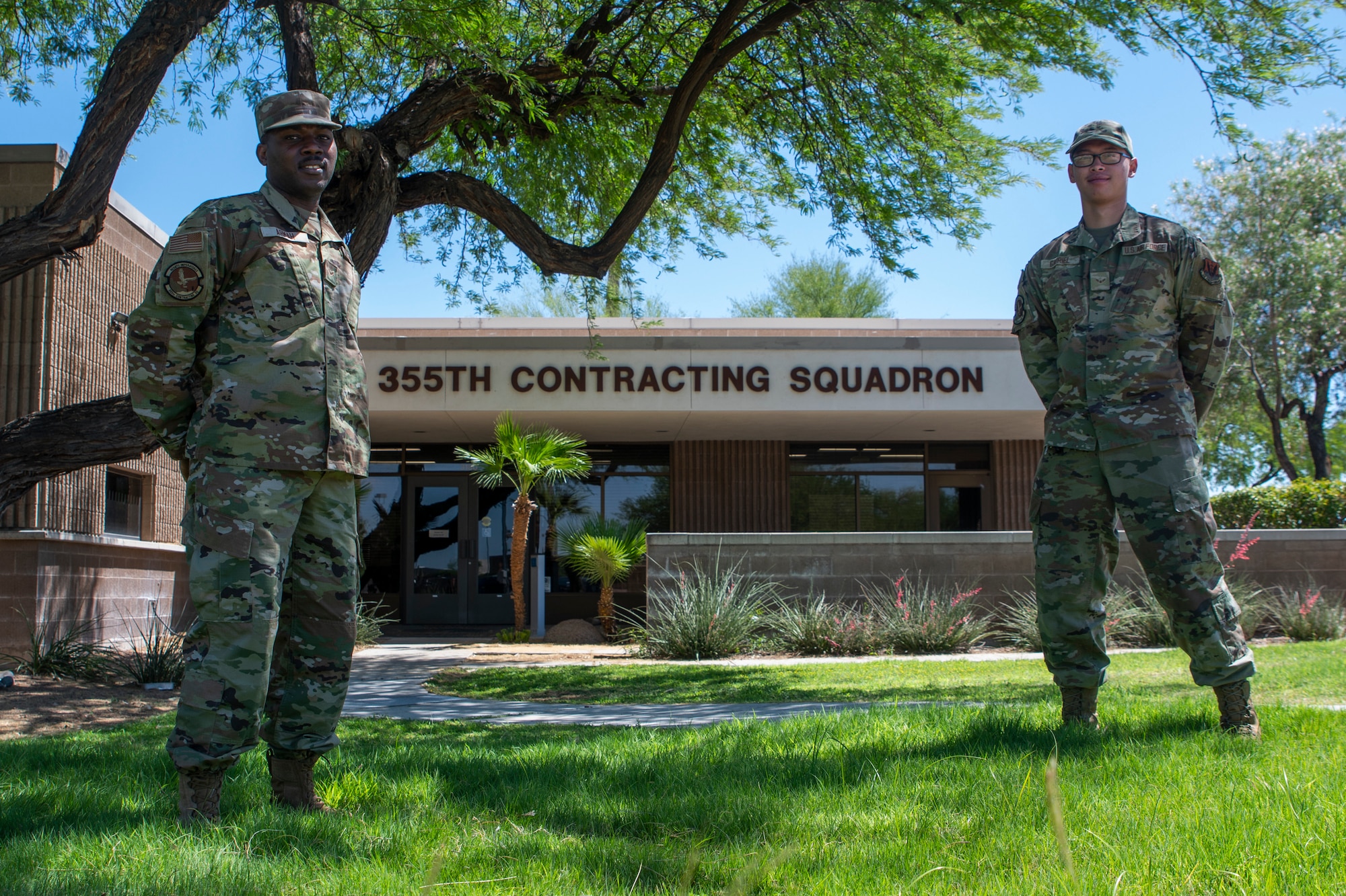 A photo of two Airmen standing in front of a building.